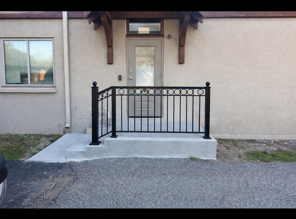 Custom black steel entry railing with circular ornamental detail